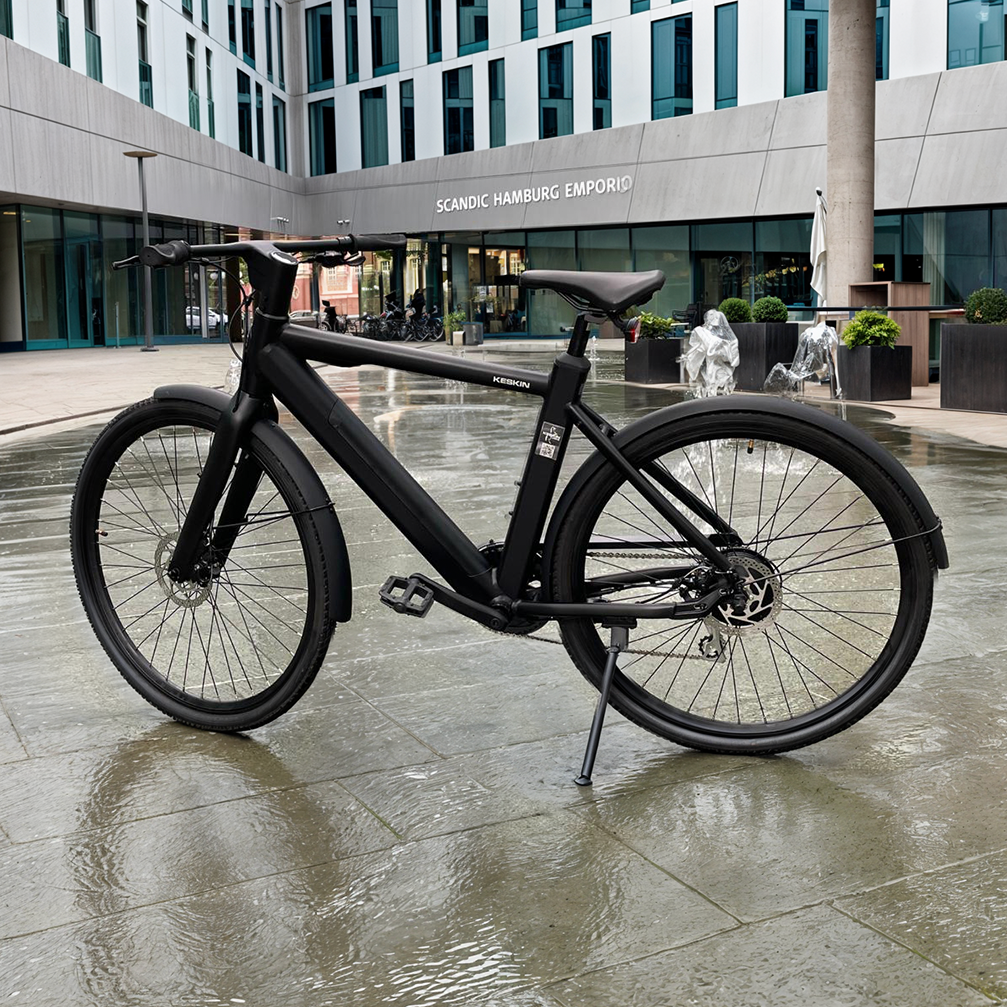 Mann mit Keskin E-Bike vor einem Unternehmen – leistungsstarkes 28 Zoll E-Bike mit Motorunterstützung für den täglichen Arbeitsweg und JobRad Leasing in Deutschland